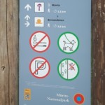 Ausschnitt eines Wegweisers im Müritz-Nationalpark, auf dem Informationen zu Wanderwegen sowie Verhaltensregeln im Schutzgebiet ausschließlich durch Symbole mit einer klaren Bildsprache vermittelt werden