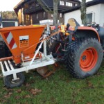 Traktor mit orangenem Anhänger in Trichterform Traktor mit orangenem Anhänger in Trichterform
