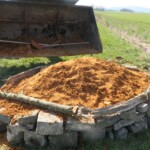 Schaufel eines Radladers neben einem mit Sand gefüllten Sandarium