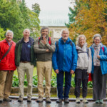 Gruppenfoto von acht Vorstandsmitgliedern in einem Park in Prag.
