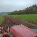 Blick aus einem Traktor auf einen gepflügten Ackersteifen