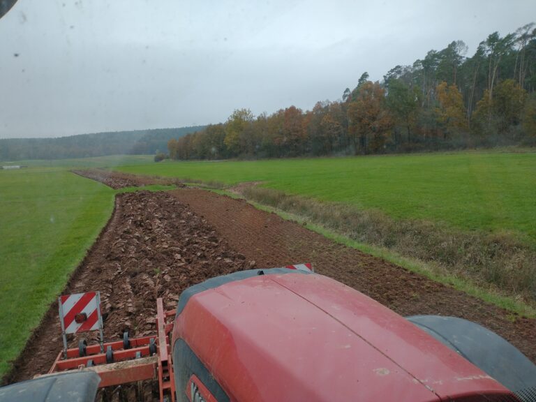 Perspektive von einem Traktor auf ein aufgebrochendes Feld