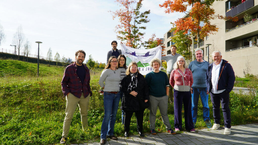 Gruppenfoto vom ersten Projekttreffen mit zehn Vertreter*innen bei Sonnenschein, in zweiter Reihe halten zwei Personen ein Banner mit der Aufschrift "Natura 2000"